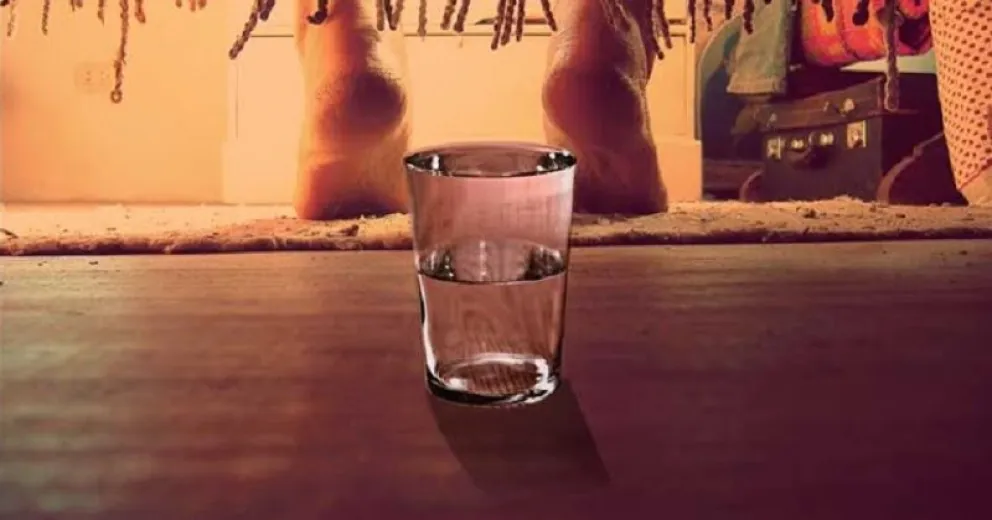 Vaso de agua abajo de la cama